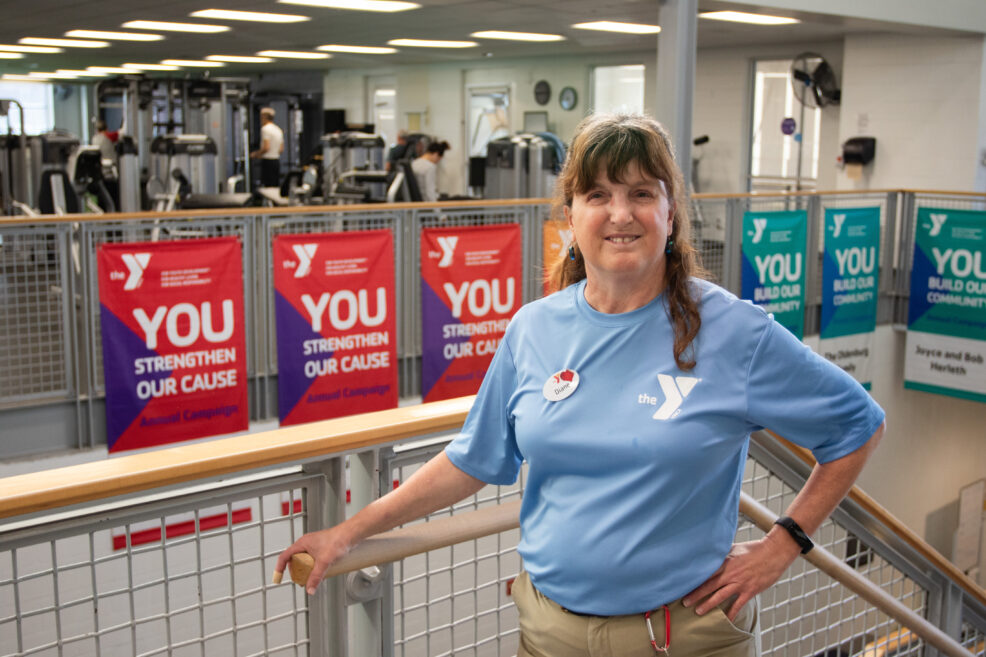 Picture of female worker in gym smiling wearing a light blue shirt.