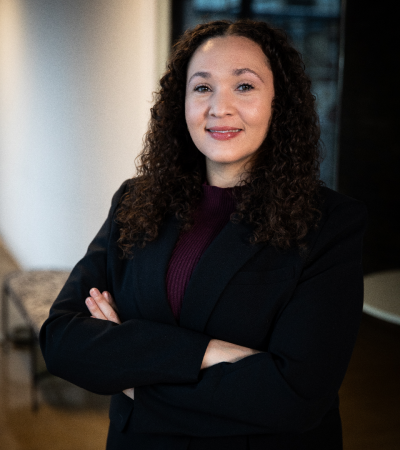 Portrait of female wearing black jacket and purple shirt.